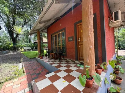 a house with a checkered floor in front of it at Manuvan Estate Stay in Kushālnagar