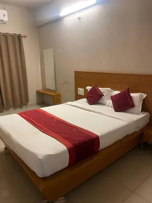 a bedroom with a large bed with red pillows at AAKI Comforts in Mysore