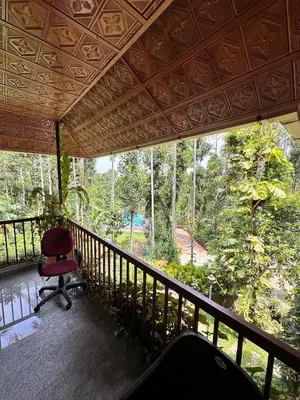 a room with a chair on a balcony at Avocado Orchards - Home Stay in Kenichira