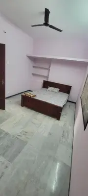 a white room with a bed and a ceiling at Sri Kamakshi Amman Home Stay in Tudiyalūr
