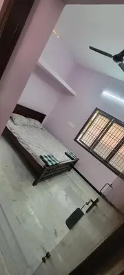 an attic room with two beds and two windows at Sri Kamakshi Amman Home Stay in Tudiyalūr