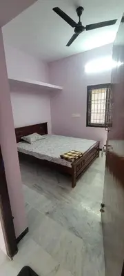 a room with a bed and a ceiling fan at Sri Kamakshi Amman Home Stay in Tudiyalūr