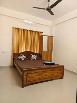 a bedroom with a large bed with two pillows at Sri Parthasarathy Inn in Guruvāyūr