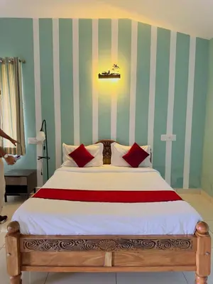 a bedroom with a large bed with red pillows at WhiteLilys Pool Retreat Kaggodlu Madikeri Coorg in Madikeri