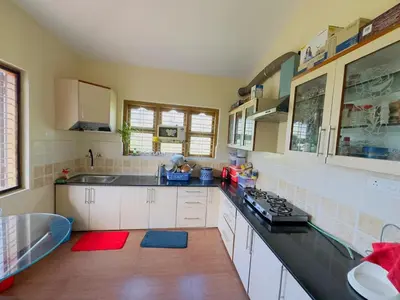 a kitchen with a sink and a stove top oven at Whitelily's Amrithasthanam in Madikeri