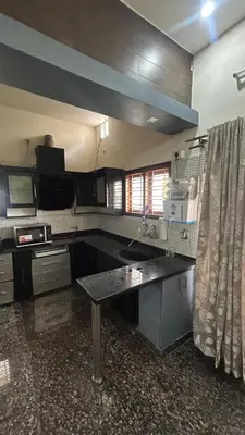a kitchen with a sink and a table in it at Aalaya in Mysore