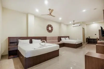 a hotel room with two beds and a couch at Kayalresidency in Gopichettipālaiyam