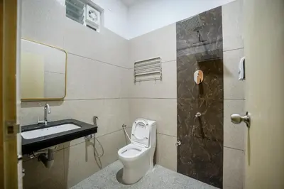 a bathroom with a toilet and a sink at Kayalresidency in Gopichettipālaiyam