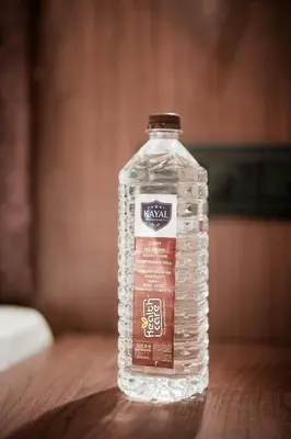 a bottle of water sitting on a wooden table at Kayalresidency in Gopichettipālaiyam