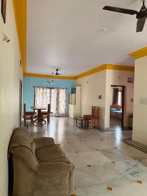 a living room with a couch and a table at Cheerful - homes Mysore stay in Mysore