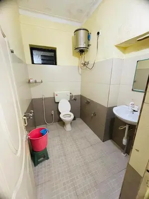 a small bathroom with a toilet and a sink at budget stay-mystique inn in Ooty