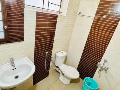 a bathroom with a toilet and a sink at Anandha Vibes STAY blessed in Guruvāyūr