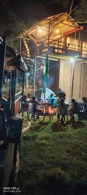 a group of tables and chairs in a yard at night at Wild Ni8 Club