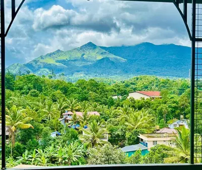 a view of a mountain from a window at Zonooro Homestay Vythiri in Vythiri