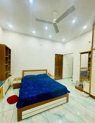 a bedroom with a bed with a blue comforter at Zonooro Homestay Vythiri in Vythiri