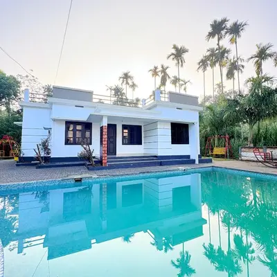 a house with a swimming pool in front of it at Grand Glorious Resort in Padinjarathara
