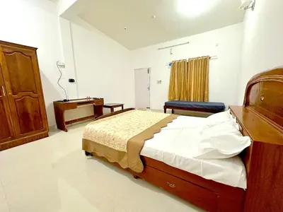 a bedroom with a bed and a dresser in it at The 77 Estate Stay in Suntikoppa