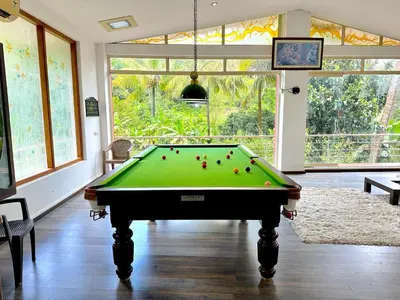 a living room with a pool table in a room at The 77 Estate Stay in Suntikoppa