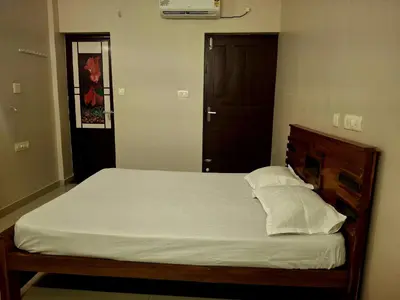 a bedroom with a large bed with white sheets and pillows at Aqua Vista beach home's in Cochin