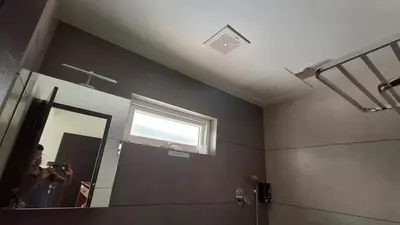 a woman taking a picture of a bathroom mirror at Mizuki Homestay in Trichūr