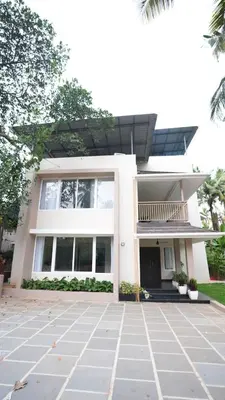 a white house with a courtyard in front of it at Mizuki Homestay in Trichūr