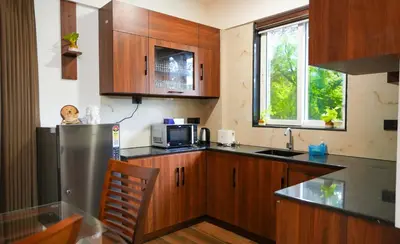 a kitchen with wooden cabinets and a stainless steel refrigerator at Mizuki Homestay in Trichūr