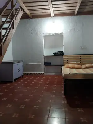 a room with two beds and a chalkboard on the wall at Nalee Farm Stay in Hunsūr