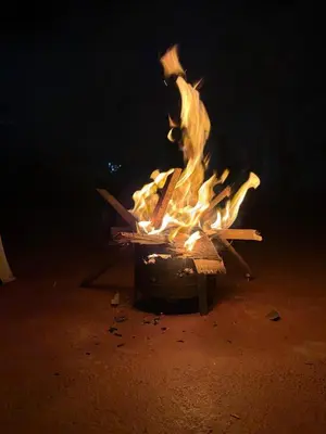 a fire in a pot on the ground at night at The Hill Bunk Heights Ooty in Ooty
