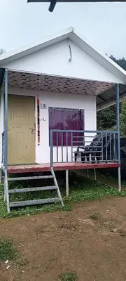 a house with a bench in front of it at Vattavada budget cottages & Aframe in Vattavada