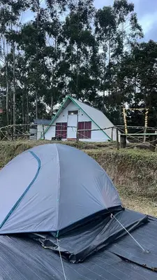 a tent laying on the ground in front of a house at Vattavada budget cottages & Aframe in Vattavada