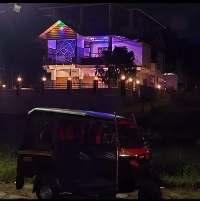 a car parked in front of a house at night at Azhagumail Honey Resort Kanthalloor in Kanthalloor