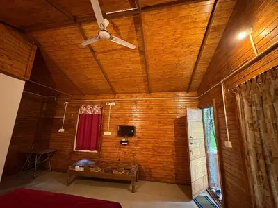 a room with wooden walls and a ceiling with a window at sireesha estate cottage stay in Madikeri