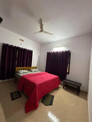 a bedroom with a red bed and purple curtains at sireesha estate cottage stay in Madikeri