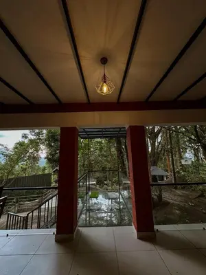 an empty house with a large glass door and a light at Rockview in Kalpetta