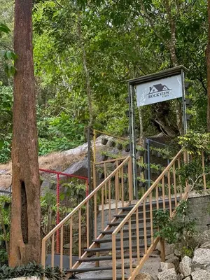 a staircase with a sign next to a tree at Rockview in Kalpetta