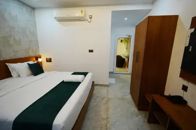 a bedroom with a large white bed with a green blanket at Palm Wave Beach Resort in Cherai Beach