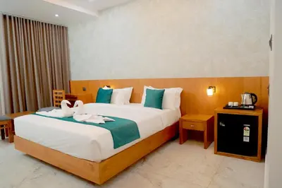 a bedroom with a bed with two swans on it at Palm Wave Beach Resort in Cherai Beach