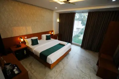 a bedroom with a large bed and a large window at Palm Wave Beach Resort in Cherai Beach