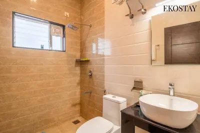 a bathroom with a white toilet and a sink at EKOSTAY - Apollo Villa in Kodaikānāl