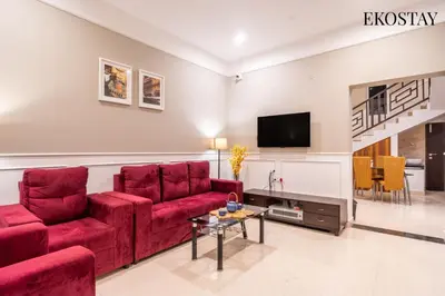 a living room with red furniture and a flat screen tv at EKOSTAY - Apollo Villa in Kodaikānāl