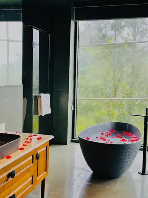 a bathroom with a large bath tub filled with red hearts at Vythiri Waves Resort l 3BR Private Pool Villa in Vayittiri