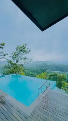 a swimming pool with a view of the mountains at Vythiri Waves Resort l 3BR Private Pool Villa in Vayittiri