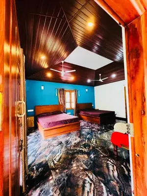 a bedroom with two beds in a room with a marble floor at Aiyappa Stayz in Madikeri