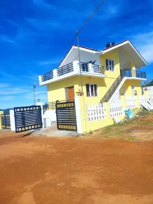 a yellow house with a fence in front of it at Ahavah Chalets in Ketti