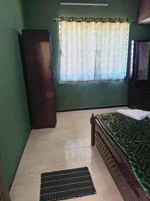 a green room with a bed and a window at Ahavah Chalets in Ketti