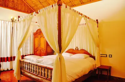 a bedroom with a canopy bed with white curtains at Hanging Huts Resorts in Kotagiri