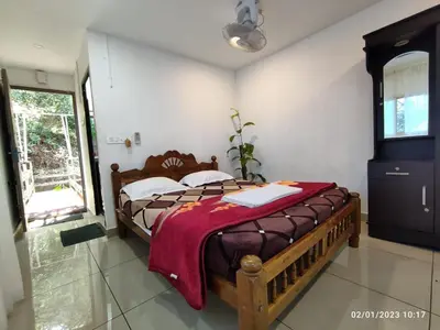a bedroom with a bed with a red blanket on it at Ponkunnu Farmstay and Resorts - Emerald - The Tree House - First Floor in Bālūssheri
