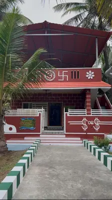 a red and white building with a red roof at Coconut Sooru,Managed By Triora Escapes in Maddūr