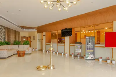 a lobby with a living room and a table at Hotel Sky International in Kizhake Chālakudi