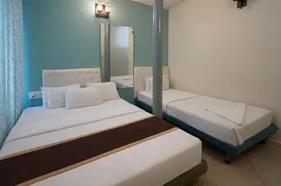 a hotel room with two beds and a mirror at Rooms By DeVerveil in Mysore